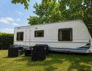 a white caravan parked on the grass in a field at Grande caravane in Gergy