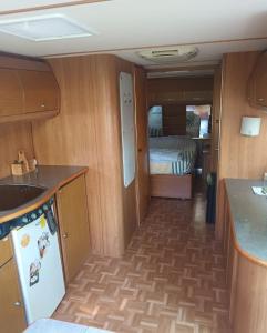 a kitchen and a room with a bed at Grande caravane in Gergy