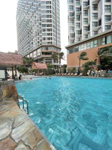 a large swimming pool in a city with tall buildings at APEC Mandala in Mui Ne +28 photos