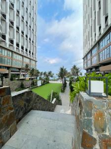 a walkway between two buildings with a green lawn at APEC Mandala in Mui Ne