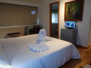 a white bed with a towel on top of it at Hotel Villa De Betanzos in Betanzos