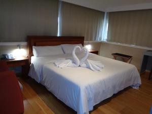 a bedroom with a bed with white towels on it at Hotel Villa De Betanzos in Betanzos
