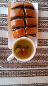 a cup of tea next to a plate of cake at Садиба у пані Марії in Vorokhta