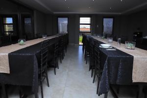 a row of tables and chairs with black table cloth at EDEN BOUTIQUE HOTEL in Kokstad