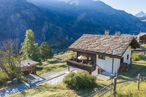 a small house with mountains in the background at Waldnest in Grächen +15 photos