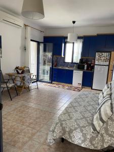 a kitchen and dining room with blue cabinets and a table at Sofia's house in Possidi