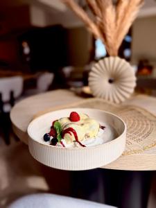 Ein weißer Teller mit einem Dessert mit Beeren auf einem Tisch in der Unterkunft Pstrągowo - domki z jacuzzi in Machowa