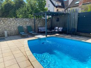 a swimming pool with chairs and a gazebo at Le nid d'Eve - studio cosy près de Strasbourg avec piscine in Illkirch-Graffenstaden