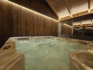 a jacuzzi tub in a wooden bathroom at Widokowe Stodoły Bieszczady-domy jacuzzi i widokiem połonin in Lesko