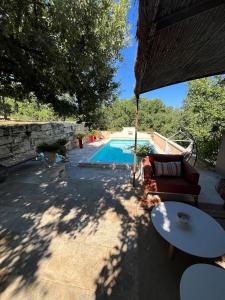 a patio with a couch and a table and a pool at Les Coustelines Piscine privée et Jacuzzi in Forcalquier