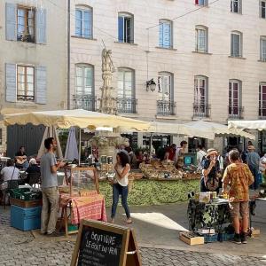a group of people standing around an outdoor market at Les Coustelines Piscine privée et Jacuzzi in Forcalquier