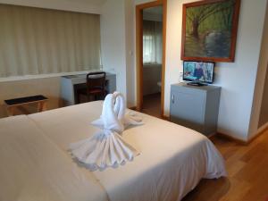 a bedroom with a bed with a towel on it at Hotel Villa De Betanzos in Betanzos