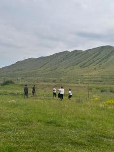 a group of people walking in a field at Kolsay Amanat Resort in Kurmenty
