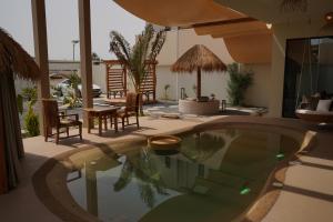 a pool in a house with chairs and a table at Wabas Al Fanar in Rumays