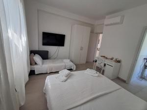 a hotel room with two beds and a television at Bouganvillea in Senigallia