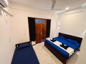 a bedroom with two beds and a door at Baywatch Arugambay in Arugam Bay