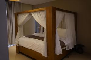 a bedroom with a canopy bed and a window at Wabas Al Fanar in Rumays +16 photos