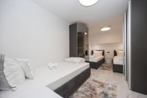 a white bedroom with two beds and a bathroom at Hotel - Teranea City Hvar in Hvar +69 photos