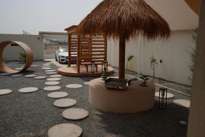 a patio with a table and a umbrella and a car at Wabas Al Fanar in Rumays