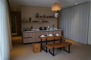 a kitchen with two benches and a table and a sink at Wabas Al Fanar in Rumays