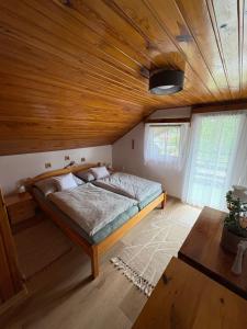 a bedroom with a bed with a wooden ceiling at Privat Medo in Děpoltovice +8 photos