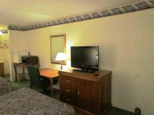 a hotel room with a flat screen tv and a desk at Travel Inn & Suites in Frankfort +3 photos