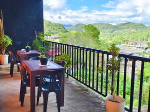 a table and chairs on a balcony with a view at Mountain Lodge within Town Proper! in Sagada