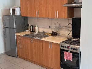 a kitchen with a sink and a stove and a refrigerator at POD BOROWIKIEM in Grzybowo