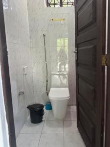 a bathroom with a toilet and a shower and a door at Warembo beach Nungwi in Nungwi