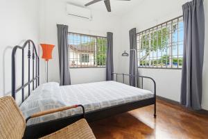 a bed in a room with two windows at Sugar Houz ruum2 in Johor Bahru