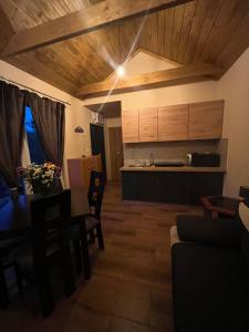a living room with a table and a kitchen at Rzeczny azyl in Pomiechówek