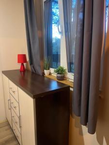 a desk with a red lamp in front of a window at Rzeczny azyl in Pomiechówek +2 photos