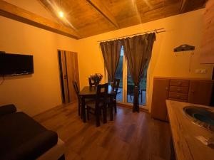 a dining room with a table and a kitchen with a window at Rzeczny azyl in Pomiechówek