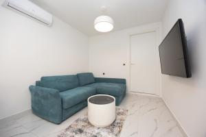 a living room with a blue couch and a flat screen tv at Hotel - Teranea City Hvar in Hvar
