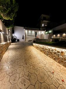 a stone walkway in front of a house at night at Katsaras Sunset & Pool House in Kremasti