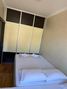 a bedroom with a bed with two towels on it at Apartman ML Company in Bečići
