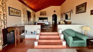 a living room with a bed and a green chair at Pakamisa Private Game Reserve in Pongola