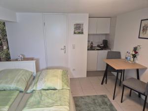 a bedroom with a bed and a table and a kitchen at Ferienwohnung Weitblick in Steinbach im Taunus
