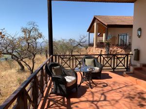 a patio with two chairs and a table on a balcony at Pakamisa Private Game Reserve in Pongola