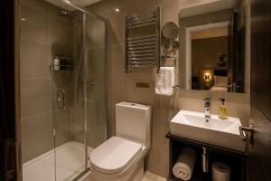 a bathroom with a shower and a toilet and a sink at Paddington Townhouse Hotel by OYO in London