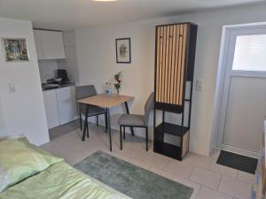 a small room with a table and a kitchen at Ferienwohnung Weitblick in Steinbach im Taunus +16 photos