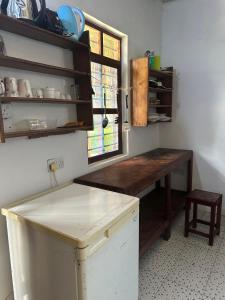 a kitchen with a wooden table and a window at Warembo beach Nungwi in Nungwi
