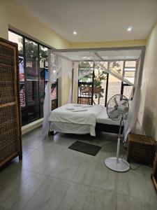 a bedroom with a bed and a fan in it at Nyanja Cottage in Chembe