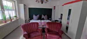 a bedroom with a bed and two chairs at Apart Königseiche in Goldenstedt