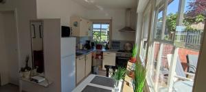 a kitchen with a white refrigerator and a large window at Apart Königseiche in Goldenstedt