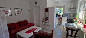 a living room with a red couch and a table at Apart Königseiche in Goldenstedt