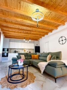 a living room with a green couch and a table at Meis Villas in Dhërmi