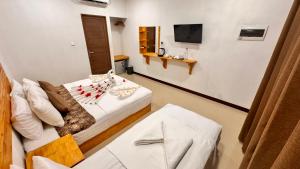 a hotel room with a bed and a television at Celeste Thoddoo Maldives in Thoddoo