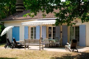 a house with a patio with chairs and a table at Moulin de Vigne in Corgnac-sur-lʼIsle