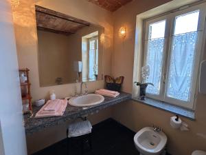 a bathroom with a sink and a toilet and a mirror at Casa Molisso in Montegrosso dʼAsti +19 photos